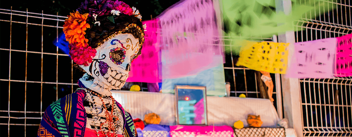 Un altar de Día de los Muertos con una figura de Catrina rodeada de papel picado.