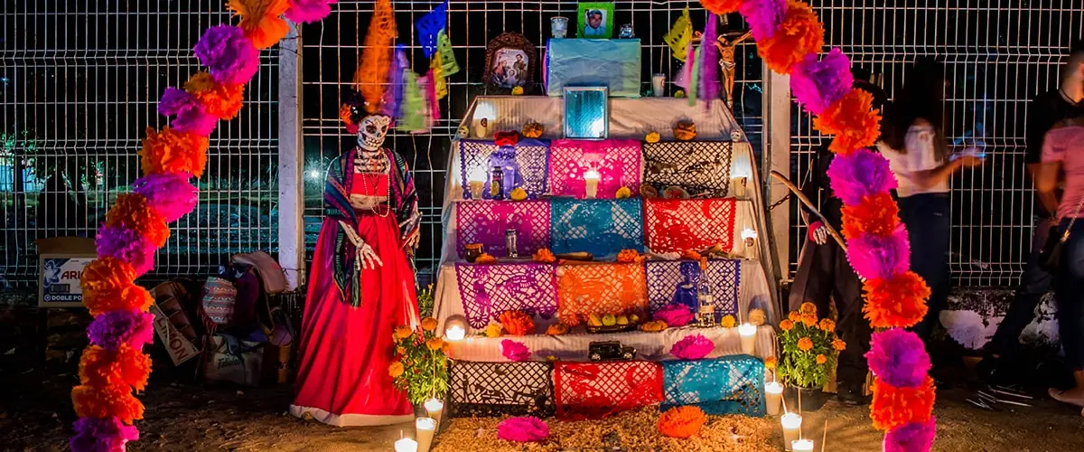 Altar y decoraciones con catrinas en celebración de día de muertos.