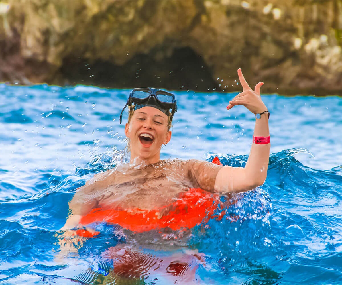Chico sonriente haciendo snorkeling en las aguas cristalinas de Puerto Vallarta.